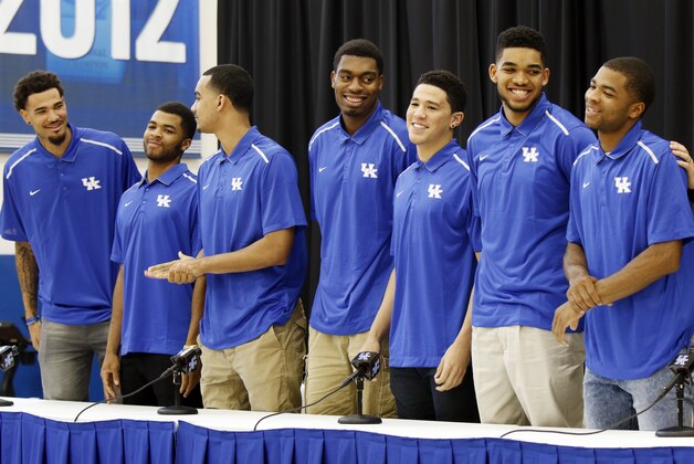 From left, Kentucky NCAA college basketball players Willie Cauley-Stein, Andrew Harrison, Trey Lyles, Dakari Johnson, Devon Booker, Karl-Anthony Towns and Aaron Harrison stand to indicate their intent to place their names in the NBA draft during a news conference at the Joe Craft Center, Thursday, April 9, 2015, in Lexington, Ky. (AP Photo/James Crisp)