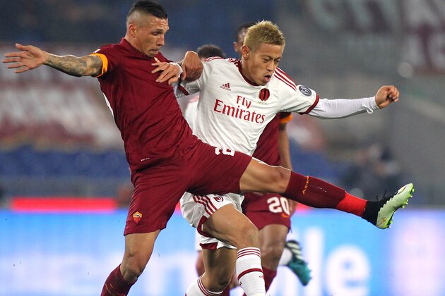 ROME, ITALY - DECEMBER 20:  Keisuke Honda (R) of AC Milan competes for the ball with Jose Holebas of AS Roma during the Serie A match betweeen AS Roma and AC Milan at Stadio Olimpico on December 20, 2014 in Rome, Italy.  (Photo by Paolo Bruno/Getty Images)