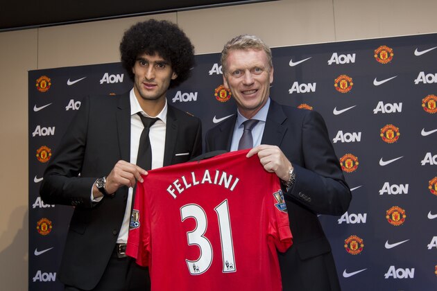 Manchester United's new signing Marouane Fellaini, left, poses for pictures with manager David Moyes before a press conference at Old Trafford Stadium, Manchester, England, Friday, Sept. 13, 2013. (AP Photo/Jon Super)