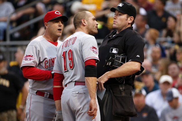 Cincinnati Reds' Joey Votto (19) bumps into umpire Chris Conroy, right, as he talks with Reds manager Bryan Price, left, during the third inning of a baseball game against the Pittsburgh Pirates, Wednesday, May 6, 2015, in Pittsburgh. Votto was ejected from the game. (AP Photo/Gene J. Puskar)