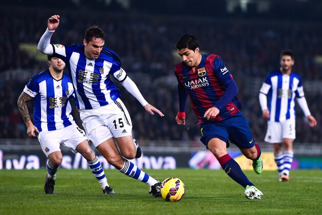 SAN SEBASTIAN, SPAIN - JANUARY 04:  Luis Suarez of FC Barcelona competes for the ball with Ion Ansotegi Gorostola of Real Sociedad during the La Liga match between Real Sociedad de Futbol and FC Barcelona at Estadio Anoeta on January 4, 2015 in San Sebastian, Spain.  (Photo by David Ramos/Getty Images)