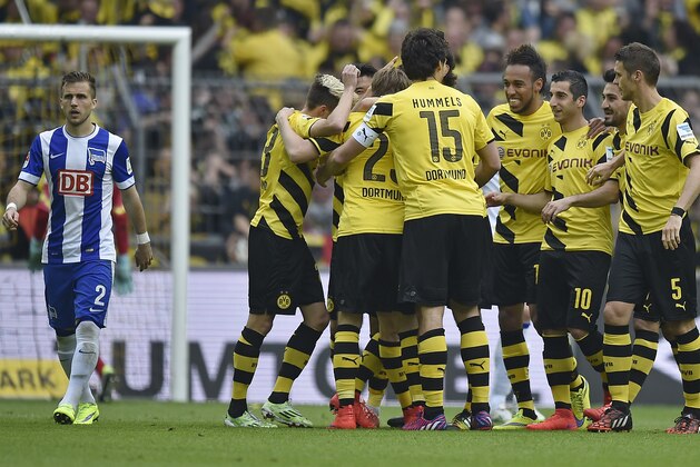 Borussia players celebrate their second goal beside Berlin's Peter Pekarik from Slovakia, left, during the German first division Bundesliga soccer match between Borussia Dortmund and Hertha BSC Berlin in Dortmund, Germany, Saturday, May 9, 2015. (AP Photo/Martin Meissner)