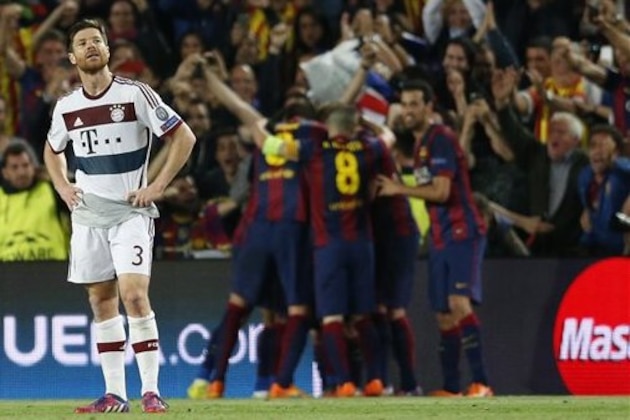 Bayern's Xabi Alonso reacts as Barcelona celebrate after scoring the opening goal during the Champions League semifinal first leg soccer match between Barcelona and Bayern Munich at the Camp Nou stadium in Barcelona, Spain, Wednesday, May 6, 2015.  (AP Photo/Manu Fernandez)