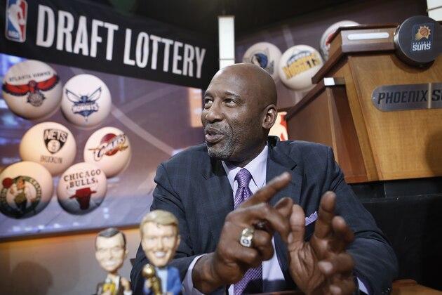 Basketball Hall of Famer James Worthy smiles before the start of the NBA basketball draft lottery in New York, Tuesday, May 20, 2014. Worthy brought bobblehead dolls of the late Lakers broadcaster Chick Hearn and the late Lakers owner Jerry Buss with him for good luck. (AP Photo/Kathy Willens)