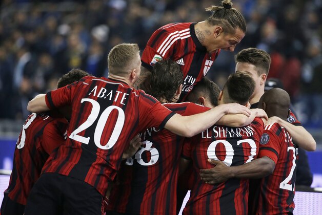 AC Milan's Jeremy Menez, hidden at center, is cheered by teammates after scoring during a Serie A soccer match between Lazio and AC Milan in Rome's Olympic stadium, Saturday, Jan. 24, 2015. (AP Photo/Gregorio Borgia)