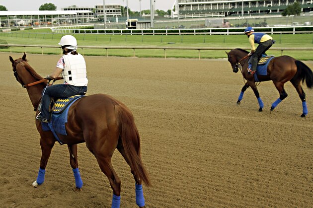 The Bob Baffert-trained duo of Dortmund, left, ridden by Dana Barnes, and American Pharoah, far right ridden by Jorge Alvarez, begin their morning workout routine at Churchill Downs in Louisville, Ky., Monday, May 11, 2015. Both horses are preparing for a start in the 140th Preakness Stakes on May 16 in Baltimore. (AP Photo/Garry Jones)