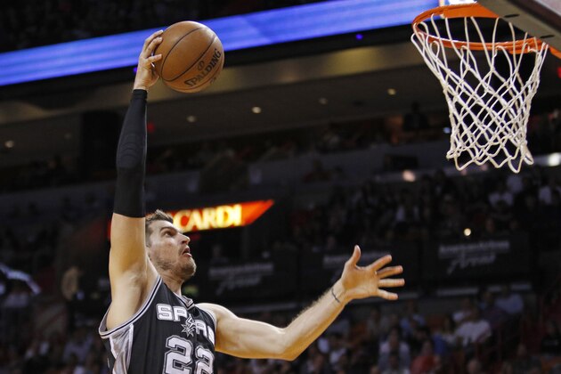 San Antonio Spurs center Tiago Splitter (22) goes high to dunk the ball against the Miami Heat in the first half of an NBA basketball game, Tuesday, March 31, 2015, in Miami. (AP Photo/Joe Skipper)