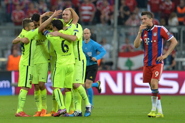 Barcelona players celebrate their victory next to Bayern's Robert Lewandowski at the end of the soccer Champions League second leg semifinal match between Bayern Munich and FC Barcelona at Allianz Arena in Munich, southern Germany, Tuesday, May 12, 2015. (AP Photo/Kerstin Joensson)