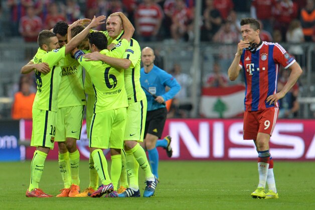 Barcelona players celebrate their victory next to Bayern's Robert Lewandowski at the end of the soccer Champions League second leg semifinal match between Bayern Munich and FC Barcelona at Allianz Arena in Munich, southern Germany, Tuesday, May 12, 2015. (AP Photo/Kerstin Joensson)
