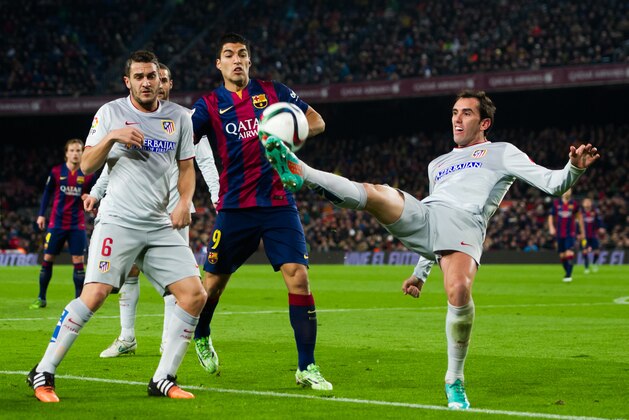 BARCELONA, SPAIN - JANUARY 21:  Diego Godin (R) of Club Atletico de Madrid plays the ball next to his teammate Jorge Resurreccion 'Koke' (L) and Luis Suarez of FC Barcelona during the Copa del Rey Quarter-Final First Leg match between FC Barcelona and Club Atletico de Madrid at Camp Nou on January 21, 2015 in Barcelona, Spain. (Photo by Alex Caparros/Getty Images)