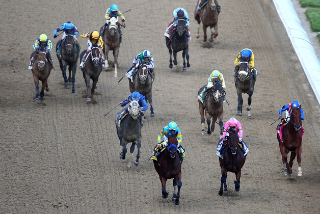 LOUISVILLE, KY - MAY 02:  American Pharoah #18, ridden by Victor Espinoza, leads the field as they head for the finish line during the 141st running of the Kentucky Derby at Churchill Downs on May 2, 2015 in Louisville, Kentucky.  (Photo by Elsa/Getty Images)