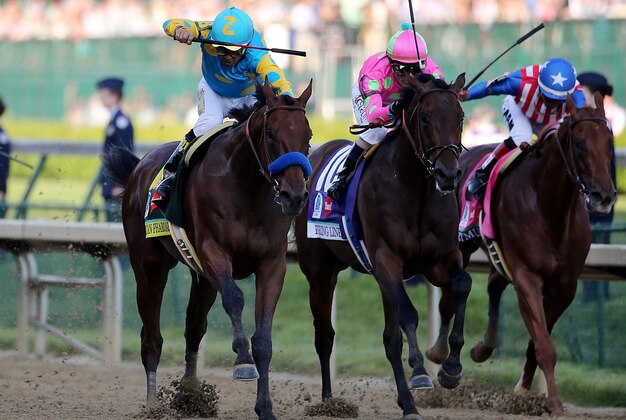 May 2, 2015; Louisville, KY, USA; Victor Espinoza aboard American Pharoah passes Gary L Stevens aboard Firing Line during the 141st Kentucky Derby at Churchill Downs. Mandatory Credit: Mark Zerof-USA TODAY Sports