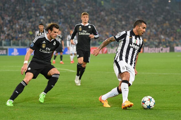 TURIN, ENGLAND - MAY 05:  Carlos Tevez of Juventus is watched by Gareth Bale of Real Madrid CF during the UEFA Champions League semi final first leg match between Juventus and Real Madrid CF at Juventus Arena on May 5, 2015 in Turin, Italy.  (Photo by Michael Regan/Getty Images)