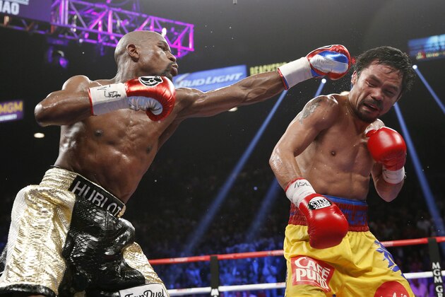 FILE - In this May 2, 2015 file photo, Floyd Mayweather Jr., left, hits Manny Pacquiao, from the Philippines, during their welterweight title fight in Las Vegas. The broadcast of fight was marred by technical snafus and got sucker punched by Internet streamers, exposing the industry’s vulnerabilities. (AP Photo/John Locher, File)