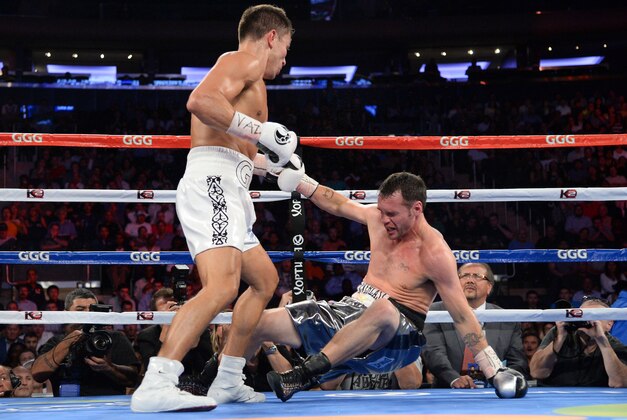 Jul 26, 2014; New York, NY, USA; Gennady Golovkin (white gloves) knocks out Daniel Geale (black gloves) during their middleweight championship bout at Madison Square Garden. Golovkin won via third round knockout. Mandatory Credit: Joe Camporeale-USA TODAY Sports