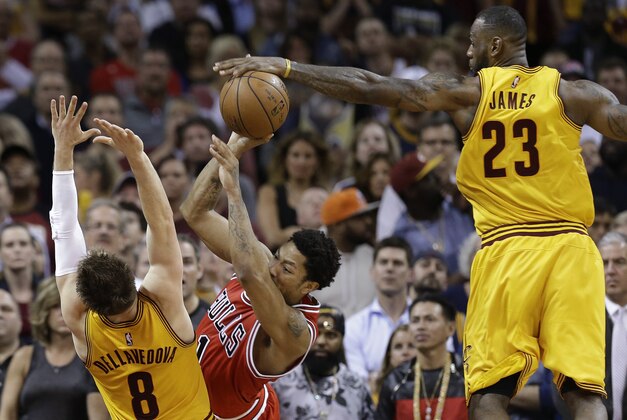 Cleveland Cavaliers forward LeBron James (23) blocks a shot by Chicago Bulls guard Derrick Rose (1) as Cavaliers guard Matthew Dellavedova (8) helps defend during the second half of Game 5 in a second-round NBA basketball playoff series Tuesday, May 12, 2015, in Cleveland. The Cavaliers won 106-101. (AP Photo/Tony Dejak)