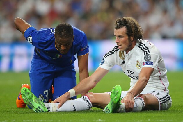 MADRID, SPAIN - MAY 13:  Patrice Evra of Juventus and Gareth Bale of Real Madrid react after a collision during the UEFA Champions League Semi Final, second leg match between Real Madrid and Juventus at Estadio Santiago Bernabeu on May 13, 2015 in Madrid, Spain.  (Photo by Alex Livesey/Getty Images)