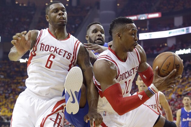 Houston Rockets' Dwight Howard (12) pulls down a rebound in front of teammate Terrence Jones (6) and Los Angeles Clippers' Glen Davis, center, during the first half in Game 5 of the NBA basketball Western Conference semifinals Tuesday, May 12, 2015, in Houston. (AP Photo/David J. Phillip)
