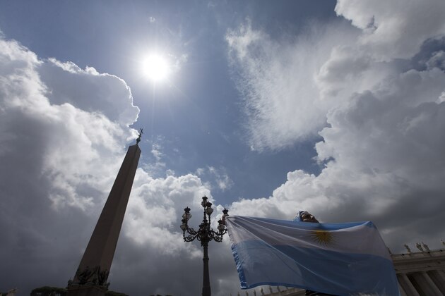 A pilgrim showing an Argentina's flag  listens to Pope Francis delivering the Angelus prayer in St. Peter square at the Vatican, Sunday, July 13, 2014. The Argentine-born, football-loving pontiff pledged neutrality, promising not to pray for any team. However, Francis did tweet on the eve of the final: