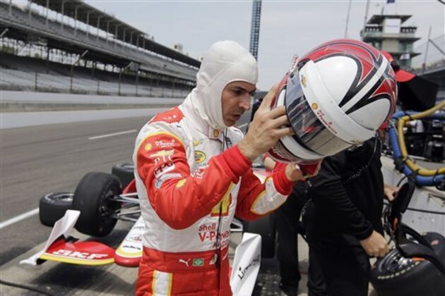 Helio Castroneves, of Brazil, pulls off his helmet following a practice session for the Indianapolis 500 auto race at Indianapolis Motor Speedway in Indianapolis, Thursday, May 14, 2015.  (AP Photo/Darron Cummings)