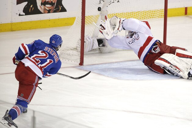 New York Rangers center Derek Stepan (21) shoots to score the game winning goal against Washington Capitals goalie Braden Holtby (70) during overtime of Game 7 of the Eastern Conference semifinals during the NHL hockey Stanley Cup playoffs Wednesday, May 13, 2015, in New York. The Rangers won 2-1. (AP Photo/Frank Franklin II)