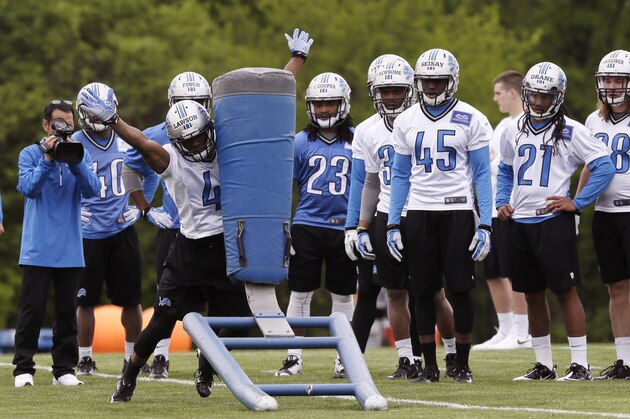 Detroit Lions teammates watch as cornerback Nevin Lawson hits a tackle sled during the Lions rookie camp in Allen Park, Mich., Friday, May 16, 2014. (AP Photo/Carlos Osorio)