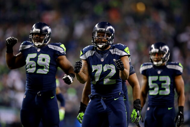 SEATTLE, WA - JANUARY 19: Defensive end Michael Bennett #72 of the Seattle Seahawks and defensive tackle Clinton McDonald #69 react against the San Francisco 49ers during the 2014 NFC Championship at CenturyLink Field on January 19, 2014 in Seattle, Washington.  (Photo by Ronald Martinez/Getty Images)