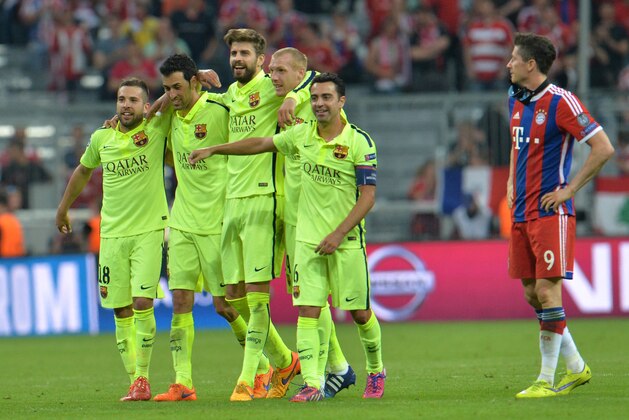 Barcelona players celebrate their victory next to Bayern's Robert Lewandowski, right, at the end of the soccer Champions League second leg semifinal match between Bayern Munich and FC Barcelona at Allianz Arena in Munich, southern Germany, Tuesday, May 12, 2015. (AP Photo/Kerstin Joensson)
