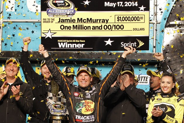 Jamie McMurray raises the mock check in Victory Lane after winning the NASCAR Sprint All-Star auto race at Charlotte Motor Speedway in Concord, N.C., Saturday, May 17, 2014. (AP Photo/Terry Renna)
