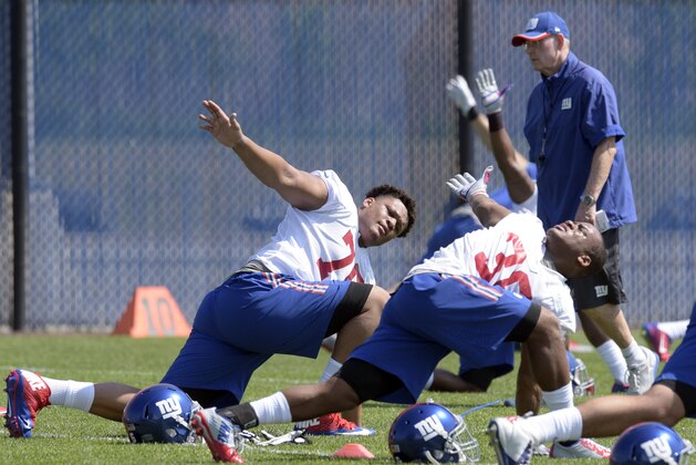 New York Giants' Ereck Flowers, left, and Anthony Cade stretch during practice at the team's NFL football rookie minicamp Friday, May 8, 2015, in East Rutherford, N.J.  (AP Photo/Bill Kostroun)