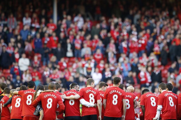 Liverpool players, some carrying their children,  wear T-shirts bearing the name and number of Steven Gerrard  after the English Premier League soccer match between Liverpool and Crystal Palace at Anfield Stadium, Liverpool, England, Saturday, May 16, 2015. Gerard played his final home match for Liverpool on Saturday at Anfield after over 700 appearances for the club, before he moves to MLS team LA Galaxy. (AP Photo/Jon Super)
