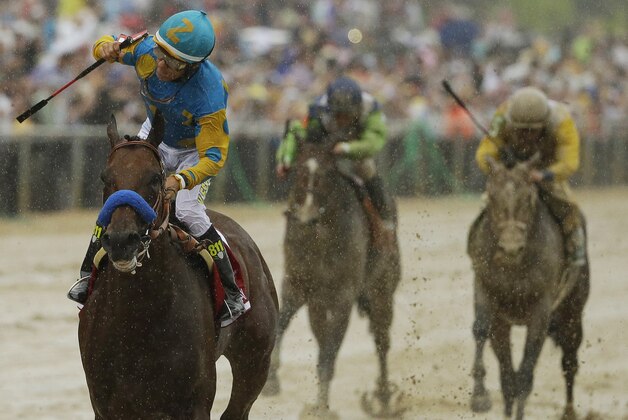 American Pharoah, ridden by Victor Espinoza, left, wins the 140th Preakness Stakes horse race at Pimlico Race Course, Saturday, May 16, 2015, in Baltimore. (AP Photo/Matt Slocum)