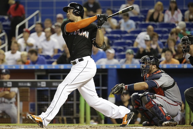 Miami Marlins' Giancarlo Stanton, left, follows through with a solo home run in the third inning of a baseball game against the Atlanta Braves, Saturday, May 16, 2015, in Miami. At right is Atlanta Braves catcher A.J. Pierzynski. (AP Photo/Lynne Sladky)