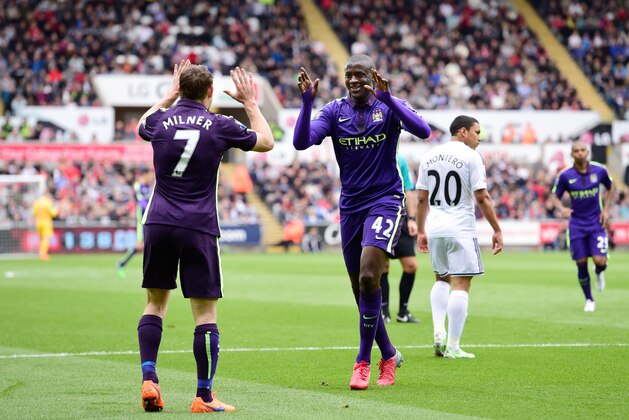 SWANSEA, WALES - MAY 17:  Yaya Toure (R) of Manchester City celebrates with teammate James Milner of Manchester City after scoring the opening goal during the Barclays Premier League match between Swansea and Manchester City at the Liberty Stadium on May 17, 2015 in Swansea, Wales.  (Photo by Stu Forster/Getty Images)