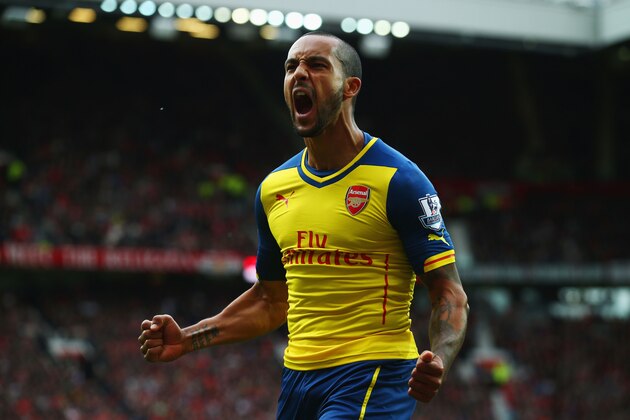 MANCHESTER, ENGLAND - MAY 17:  Theo Walcott of Arsenal celebrates as his cross deflects of off Tyler Blackett of Manchester United for an own goal during the Barclays Premier League match between Manchester United and Arsenal at Old Trafford on May 17, 2015 in Manchester, England.  (Photo by Clive Rose/Getty Images)