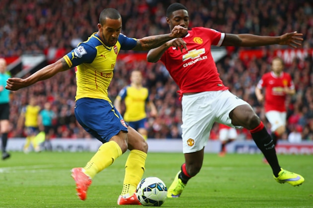 MANCHESTER, ENGLAND - MAY 17:  Theo Walcott of Arsenal crosses the ball which deflects of off Tyler Blackett of Manchester United for an own goal during the Barclays Premier League match between Manchester United and Arsenal at Old Trafford on May 17, 2015 in Manchester, England.  (Photo by Clive Rose/Getty Images)