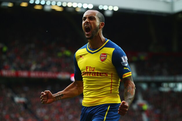 MANCHESTER, ENGLAND - MAY 17:  Theo Walcott of Arsenal celebrates as his cross deflects of off Tyler Blackett of Manchester United for an own goal during the Barclays Premier League match between Manchester United and Arsenal at Old Trafford on May 17, 2015 in Manchester, England.  (Photo by Clive Rose/Getty Images)