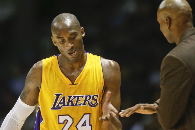 Los Angeles Lakers guard Kobe Bryant gets a hand slap from coach Byron Scott after leaving the Lakers' game against the Denver Nuggets during the first half of a NBA preseason basketball game  Monday, Oct. 6, 2014, in San Diego. (AP Photo/Lenny Ignelzi