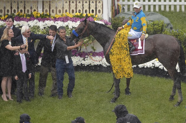 Victor Espinoza and his mount American Pharoah pose for photos after winning the 140th Preakness Stakes horse race at Pimlico Race Course, Saturday, May 16, 2015, in Baltimore. Bob Baffert his son Bode and Jill Baffert look on at left. (AP Photo/Nick Wass)
