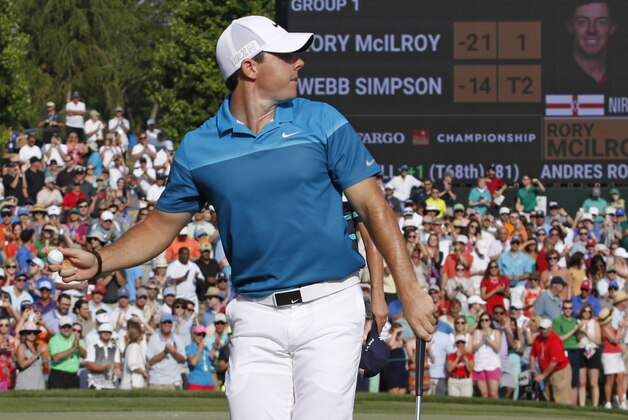 Rory McIlroy, of Northern Ireland, prepares to throw his ball into the crowd as he celebrates after winning the Wells Fargo Championship golf tournament at Quail Hollow Club in Charlotte, N.C., Sunday, May 17, 2015. (AP Photo/Bob Leverone)
