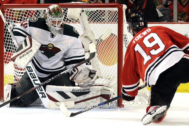 Minnesota Wild goalie Devan Dubnyk, left, fails to stop a shot and goal  by Chicago Blackhawks center Jonathan Toews, right, during the second period  of Game 2 in the second round of the NHL Stanley Cup hockey playoffs in Chicago, Sunday, May 3, 2015. (AP Photo/Nam Y. Huh)