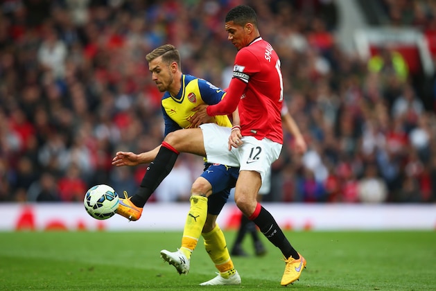 MANCHESTER, ENGLAND - MAY 17:  Aaron Ramsey of Arsenal holds off Chris Smalling of Manchester United during the Barclays Premier League match between Manchester United and Arsenal at Old Trafford on May 17, 2015 in Manchester, England.  (Photo by Clive Rose/Getty Images)