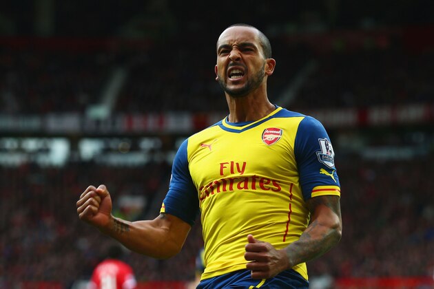 MANCHESTER, ENGLAND - MAY 17:  Theo Walcott of Arsenal celebrates as his cross deflects off of Tyler Blackett of Manchester United for an own goal during the Barclays Premier League match between Manchester United and Arsenal at Old Trafford on May 17, 2015 in Manchester, England.  (Photo by Clive Rose/Getty Images)