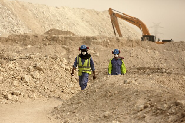 In this photo taken during a government organized media tour, workers walk back to the Al-Wakra Stadium worksite being built for the 2022 World Cup, in Doha, Qatar, Monday, May 4, 2015. Qatar’s inability to ensure decent housing for its bulging migrant labor population was “a mistake” the government is working to fix as it prepares to host the 2022 World Cup, the country’s top labor official said Monday, vowing his country would improve conditions for its vast foreign labor force. (AP Photo/Maya Alleruzzo)