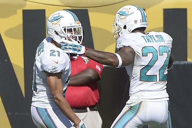 Miami Dolphins cornerback Brent Grimes (21) and cornerback Jamar Taylor (22) celebrate after Grimes intercepted a pass and returned it for 22-yards and a touchdown during the first half of an NFL football game in Jacksonville, Fla., Sunday, Oct. 26, 2014. (AP Photo/Phelan M. Ebenhack)