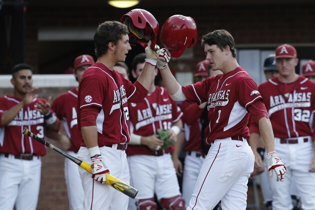 Arkansas infielder Brian Anderson (1) tips his helmet to teammate Eric Fisher (29)  after he hit a solo home run in the second inning against Liberty during an NCAA college baseball tournament regional game in Charlottesville, Va., Friday, May 30, 2014.   (AP Photo/Steve Helber)