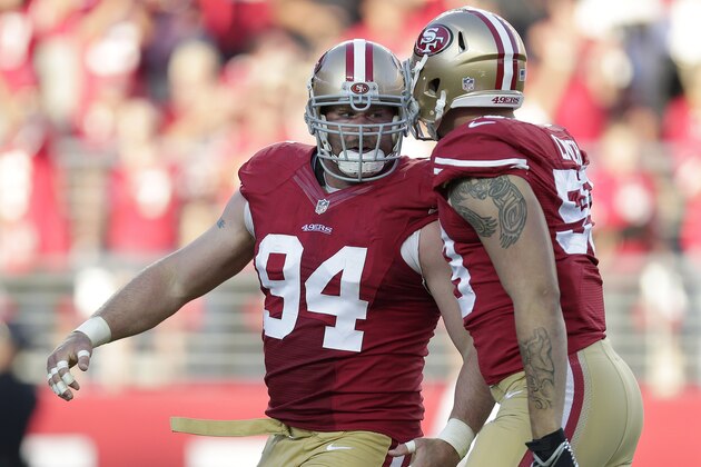 San Francisco 49ers defensive tackle Justin Smith (94) celebrates after sacking Chicago Bears quarterback Jay Cutler with linebacker Aaron Lynch during the second quarter of an NFL football game in Santa Clara, Calif., Sunday, Sept. 14, 2014. (AP Photo/Marcio Jose Sanchez)