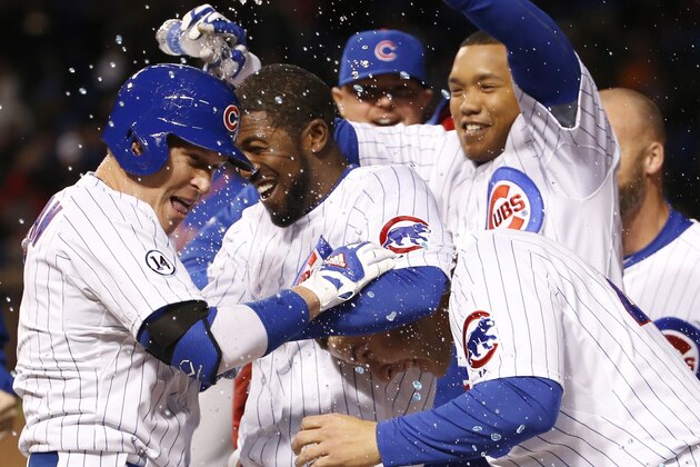 Chicago Cubs' Chris Coghlan, left, celebrates with teammates after he drew a bases loaded walk from New York Mets relief pitcher Jeurys Familia, in the bottom of the ninth, scoring Matt Szczur after a baseball game Wednesday, May 13, 2015, in Chicago. The Cubs won 2-1. (AP Photo/Charles Rex Arbogast)