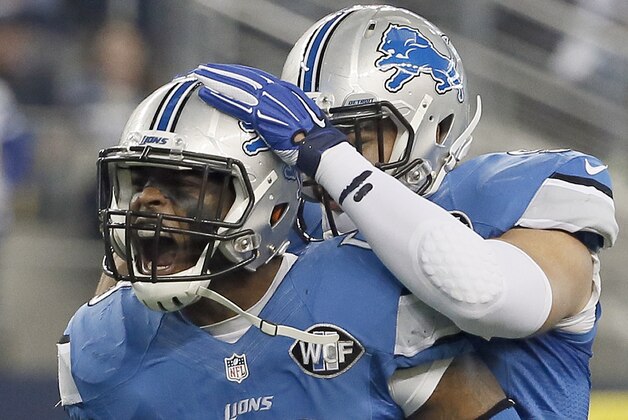 Detroit Lions middle linebacker Tahir Whitehead (59) celebrates sacking Dallas Cowboys quarterback Tony Romo (9) with outside linebacker Kyle Van Noy (95) during the first half of an NFL wildcard playoff football game, Sunday, Jan. 4, 2015, in Arlington, Texas. (AP Photo/Tony Gutierrez)