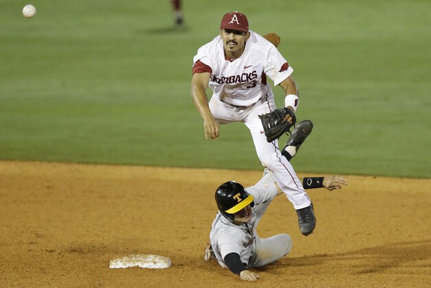 Arkansas second baseman Michael Bernal, top, throws to first after forcing out Tennessee's Jordan Rodgers at second base during the eighth inning of a Southeastern Conference college baseball tournament game Tuesday, May 19, 2015, in Hoover, Ala. (AP Photo/Brynn Anderson)